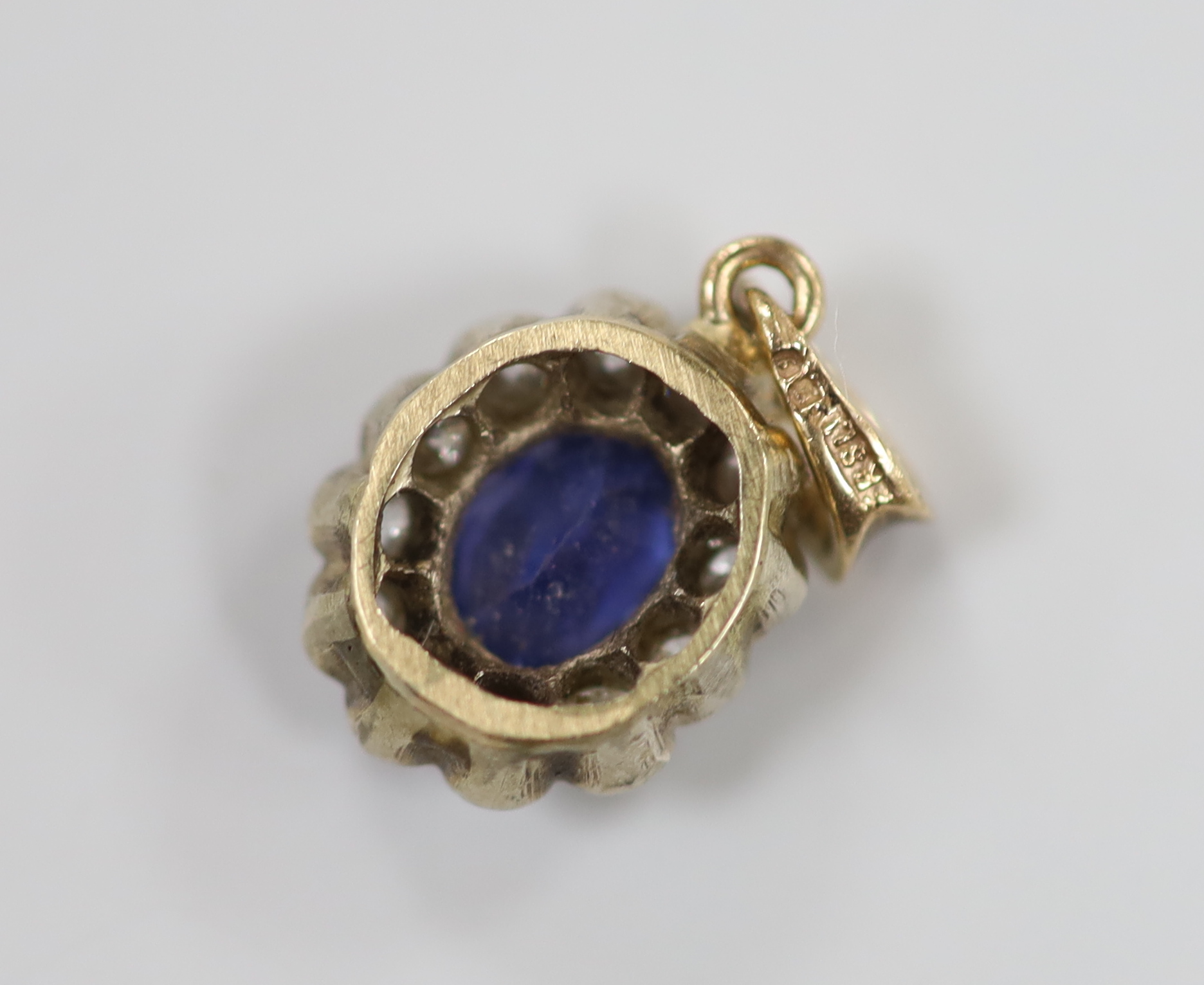 A yellow metal, sapphire and diamond set oval cluster pendant, 11mm, gross weight 1.6 grams.